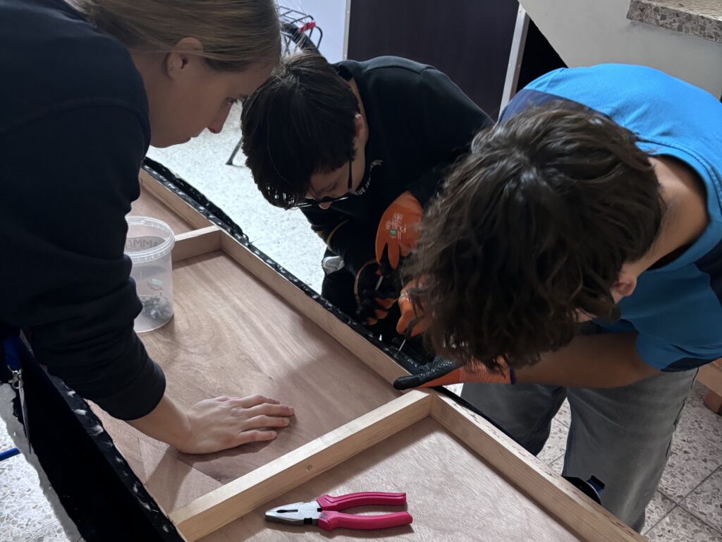 Ines Kirchengast bei der Unterstützung von zwei Jugendlichen beim Zerlegen von Abfällen des MAKs, um neues daraus zu bauen