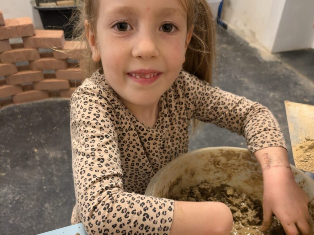 Mädchen beim machen eines Lehmziegels