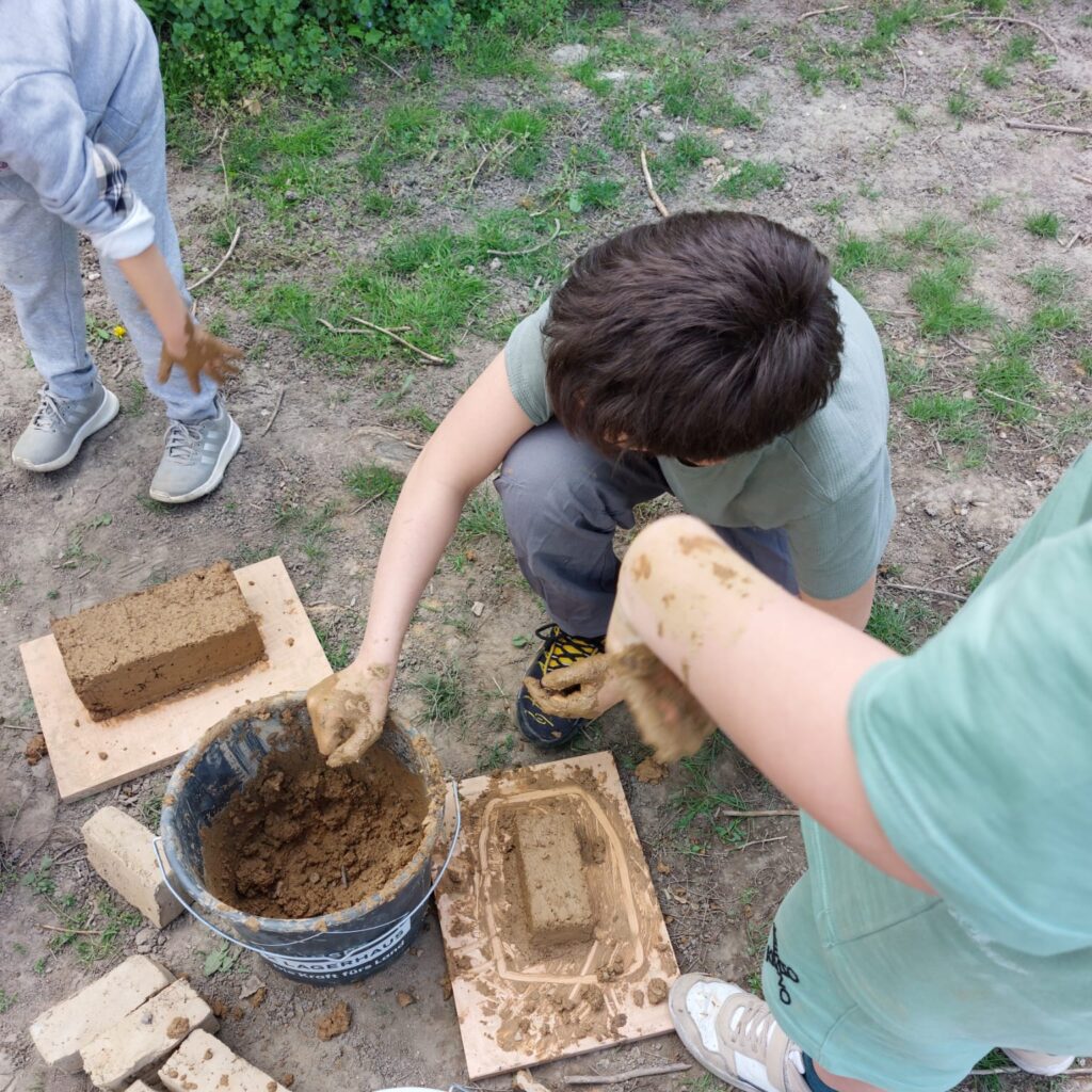 Kinder beim Bau von Lehmziegeln im TU Wien Transformer - Nachhaltiges Bauen hands-on