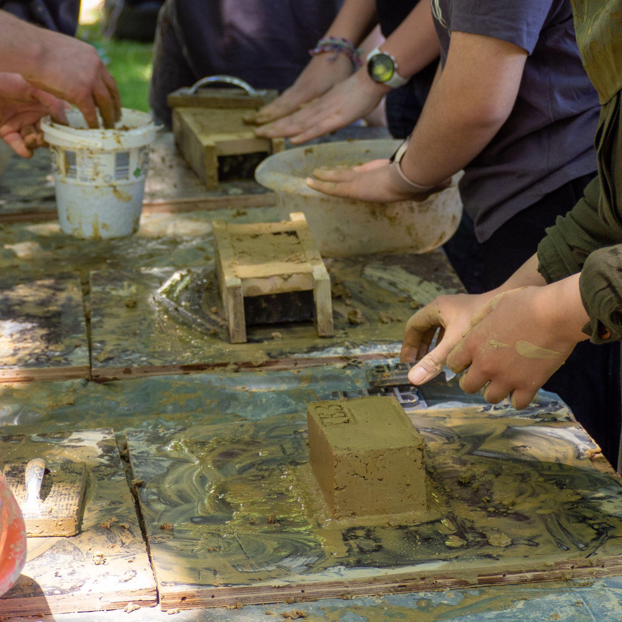 Kinder beim Lehmziegel herstellen