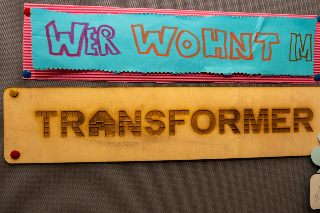Mit dem Lasercutter graviertes Holzschild mit dem Schriftzug TRANSFORMER – Beispiel für ein Logo aus Holz beim Teambuilding